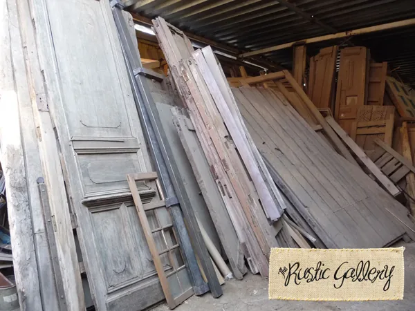 Old wooden doors and boards stacked upright in a warehouse