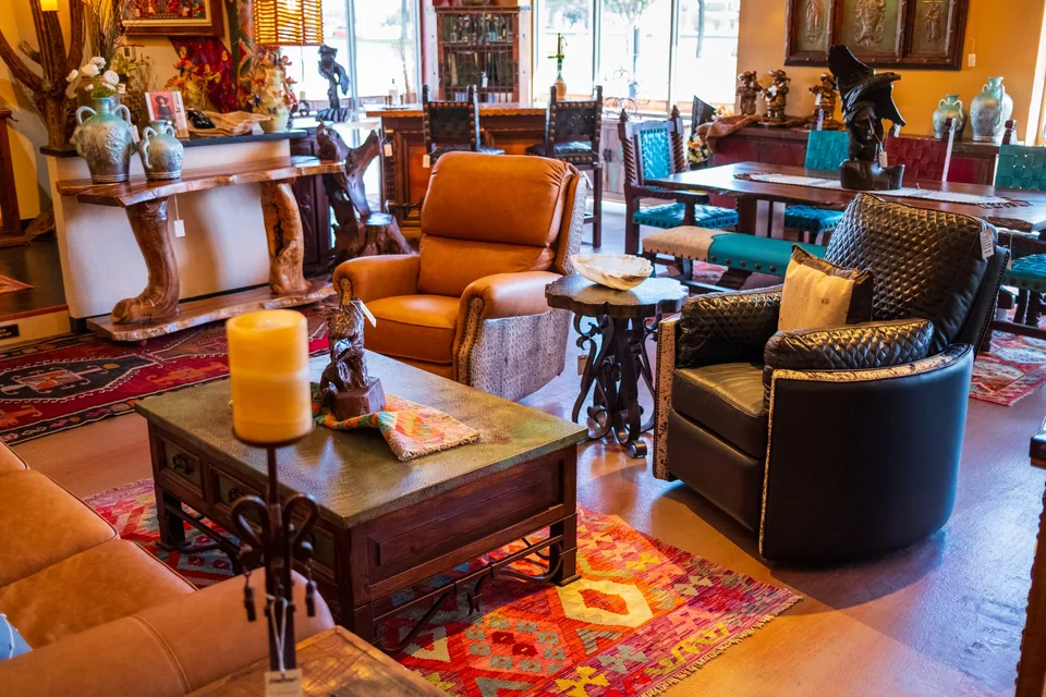 Leather armchairs and a wooden coffee table on a red rug in the showroom